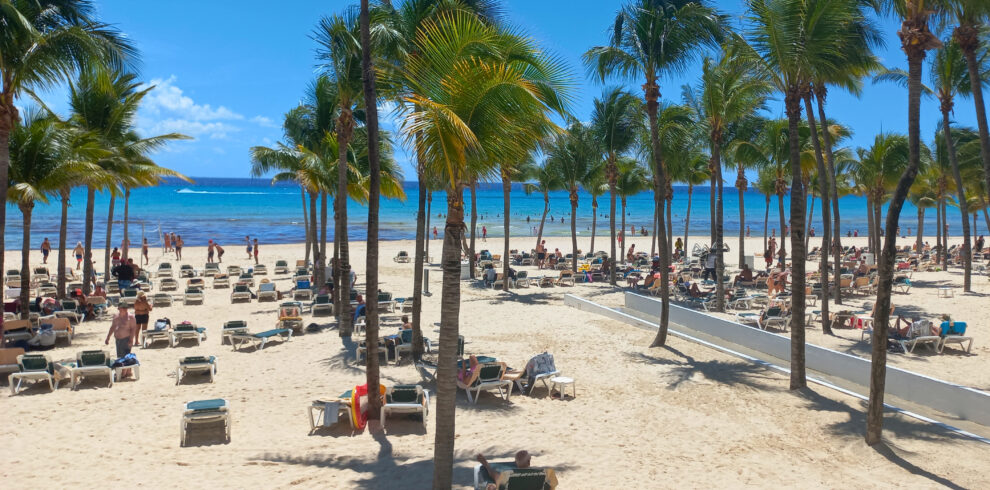 Strand in Playa del Carmen met palmbomen en ligbedjes