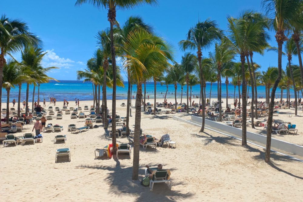 Strand in Playa del Carmen met palmbomen en ligbedjes